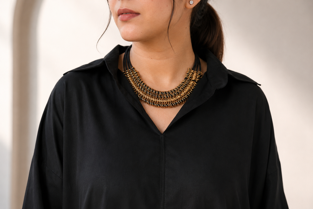 Model wearing black pure lawn one-piece kurta in a seated styling look