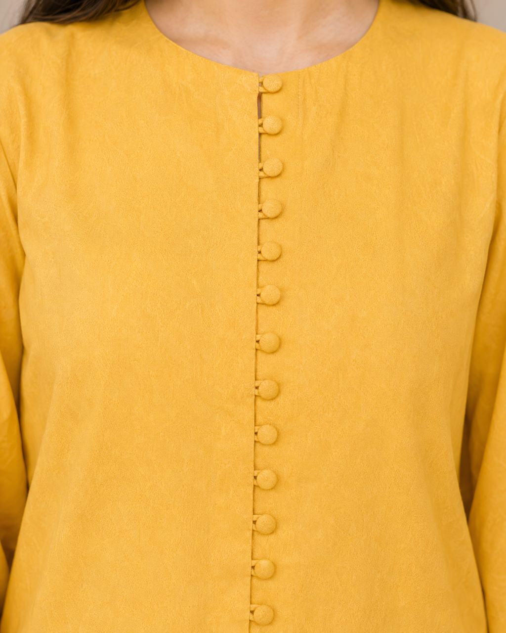 Close-up of mustard yellow Irish linen shirt with covered buttons