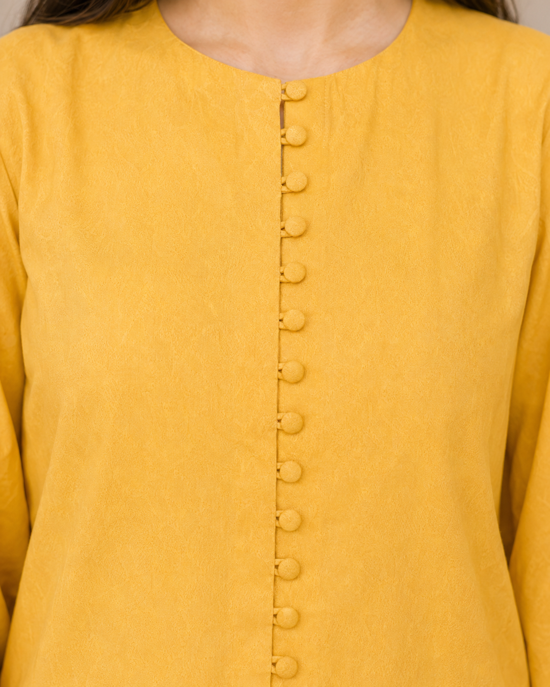 Close-up of mustard yellow Irish linen shirt with covered buttons
